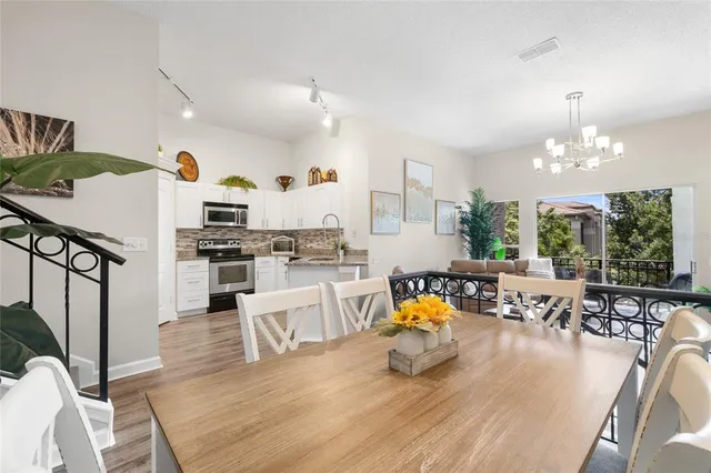 a living room with furniture dining table a large window and kitchen view