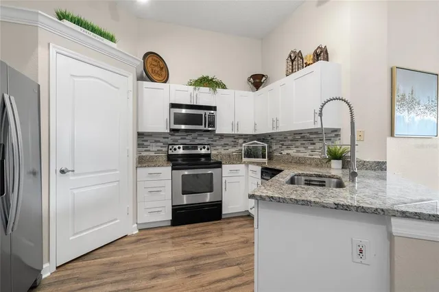 a kitchen with stainless steel appliances granite countertop a stove a sink and a refrigerator