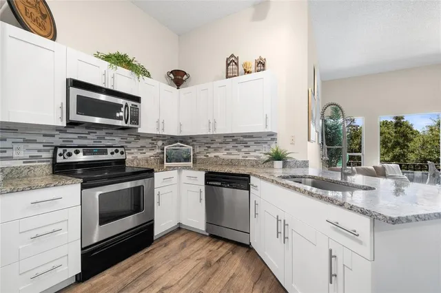 a kitchen with granite countertop cabinets stainless steel appliances and a counter space