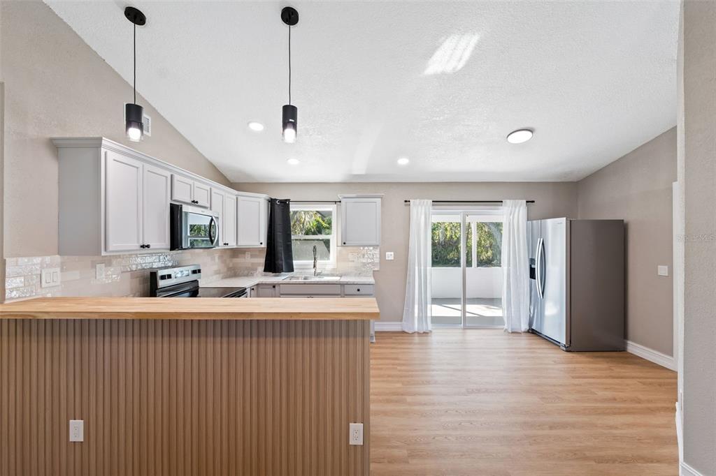606 Kings Lane Southwest Winter Haven, FL 33880 - Photo 11 of 50 a room with stainless steel appliances granite countertop furniture and a wooden floor