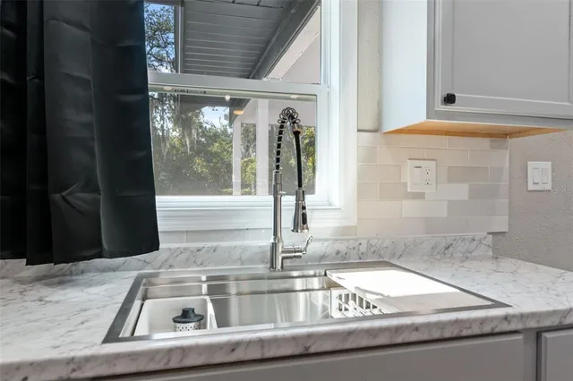 a view of a kitchen with granite countertop a sink and a window