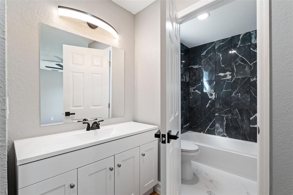 606 Kings Lane Southwest Winter Haven, FL 33880 - Photo 17 of 50 a bathroom with a bathtub shower sink vanity and toilet