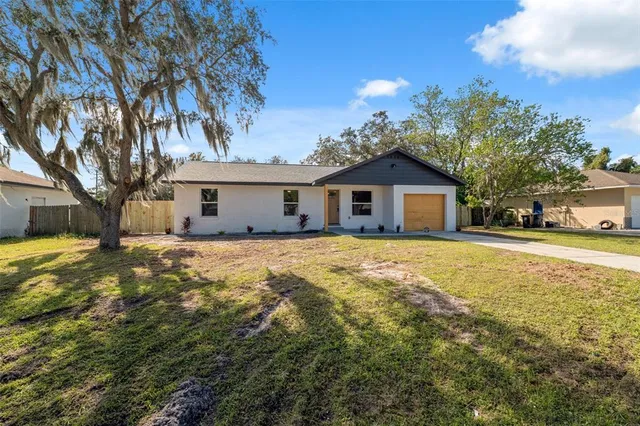 a front view of house with yard and trees around