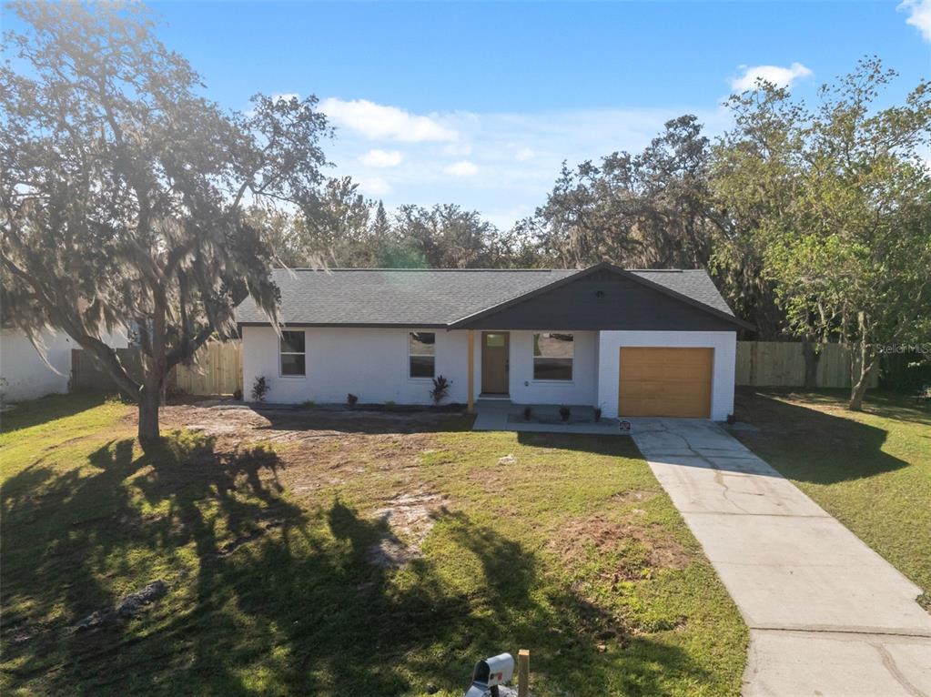 606 Kings Lane Southwest Winter Haven, FL 33880 - Photo 36 of 50 a front view of house with yard and trees in the background