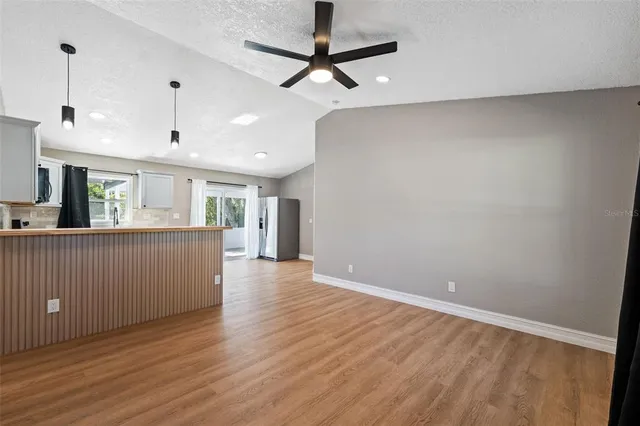 a view of a kitchen with wooden floor and a ceiling fan