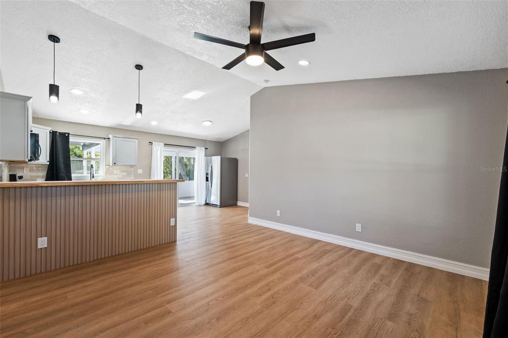 606 Kings Lane Southwest Winter Haven, FL 33880 - Photo 4 of 50 a view of a kitchen with wooden floor and a ceiling fan