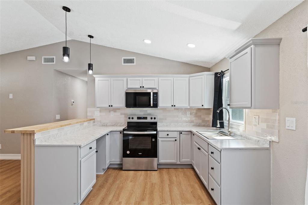 606 Kings Lane Southwest Winter Haven, FL 33880 - Photo 8 of 50 a kitchen with granite countertop a sink appliances cabinets and a counter top space