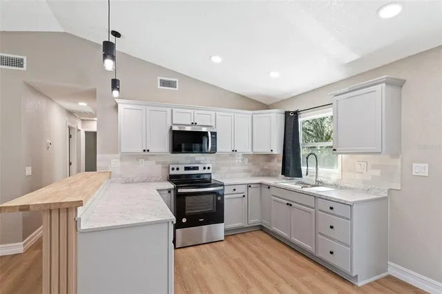 a kitchen with stainless steel appliances a sink stove and refrigerator
