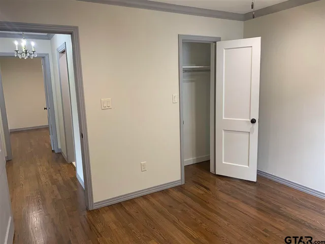 an empty room with wooden floor and closet