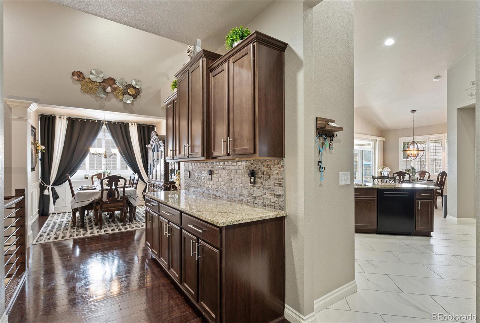 8841 Peakview Avenue Firestone, CO 80504 - Photo 14 of 40 a kitchen with stainless steel appliances granite countertop a refrigerator a stove and a wooden floors