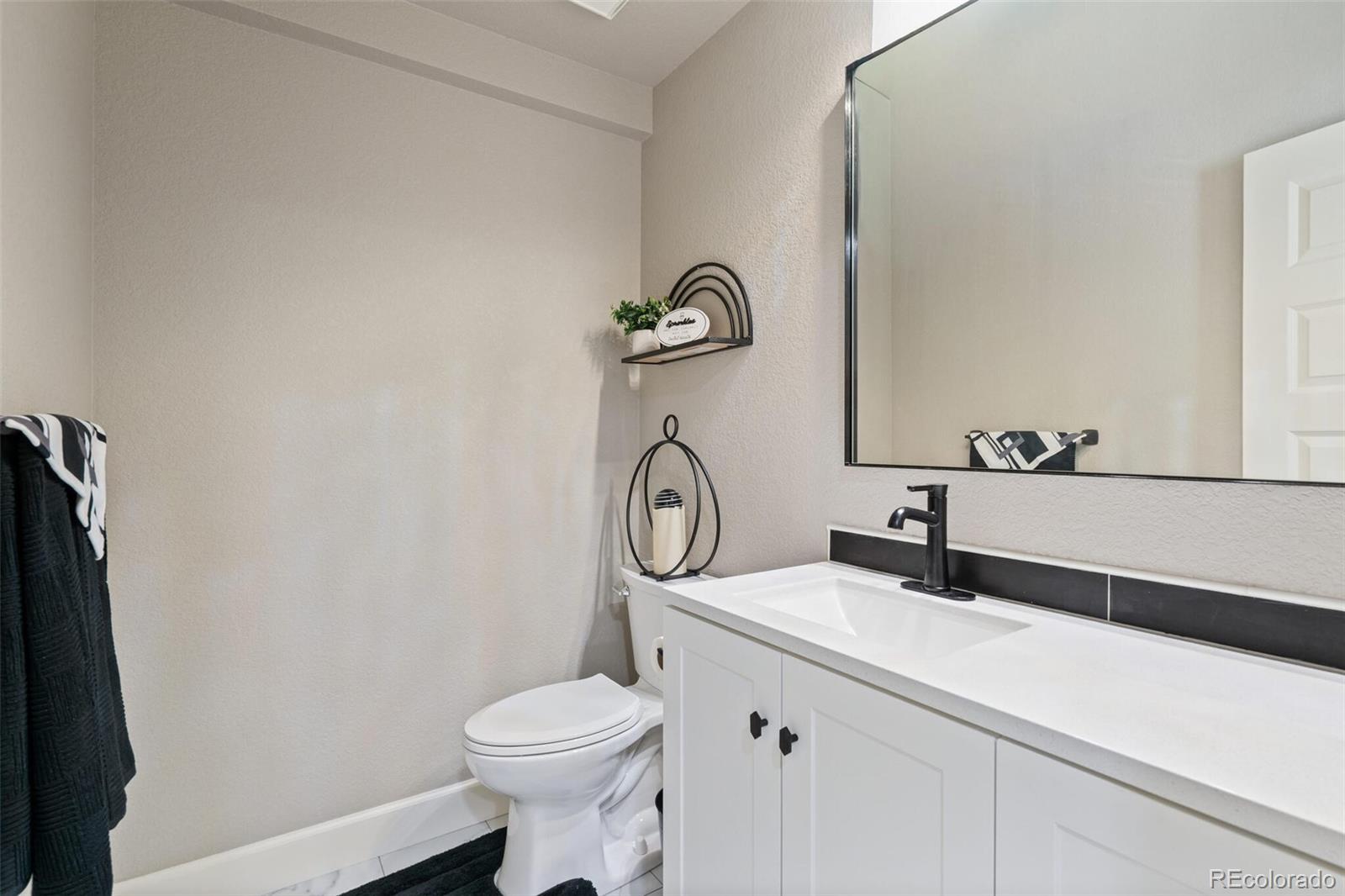 8841 Peakview Avenue Firestone, CO 80504 - Photo 26 of 40 a bathroom with a toilet sink and mirror