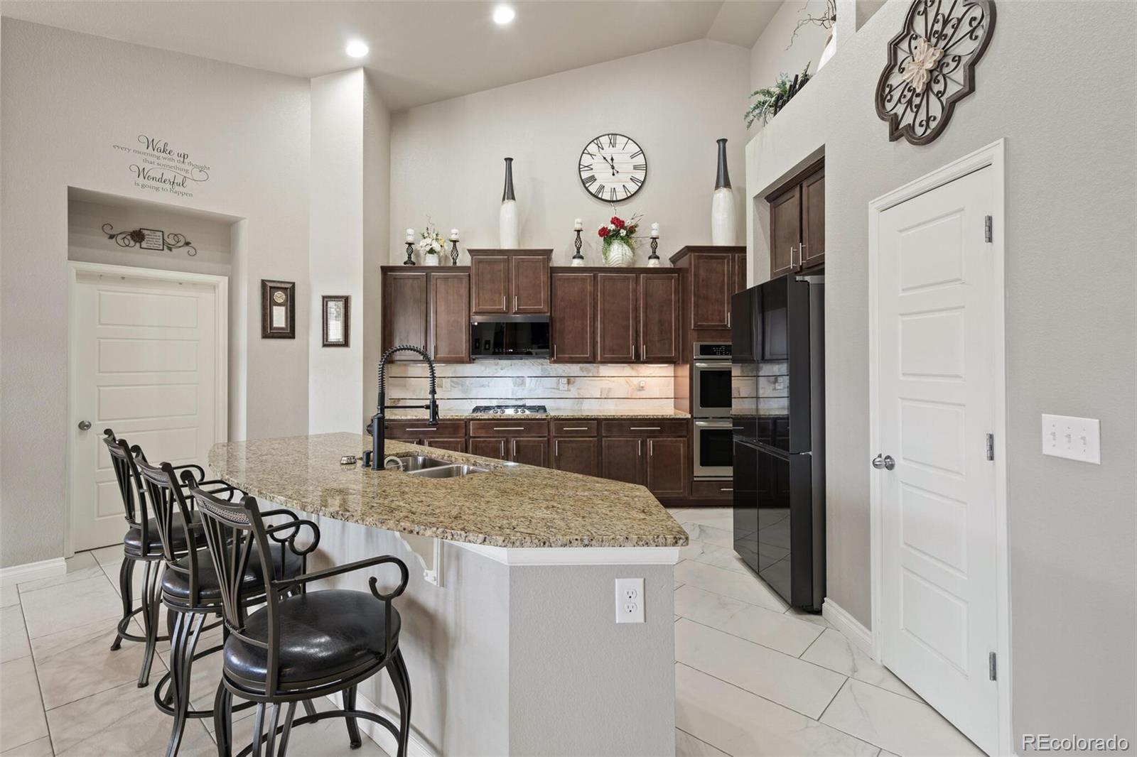 8841 Peakview Avenue Firestone, CO 80504 - Photo 4 of 40 a kitchen with stainless steel appliances granite countertop a table chairs and a refrigerator