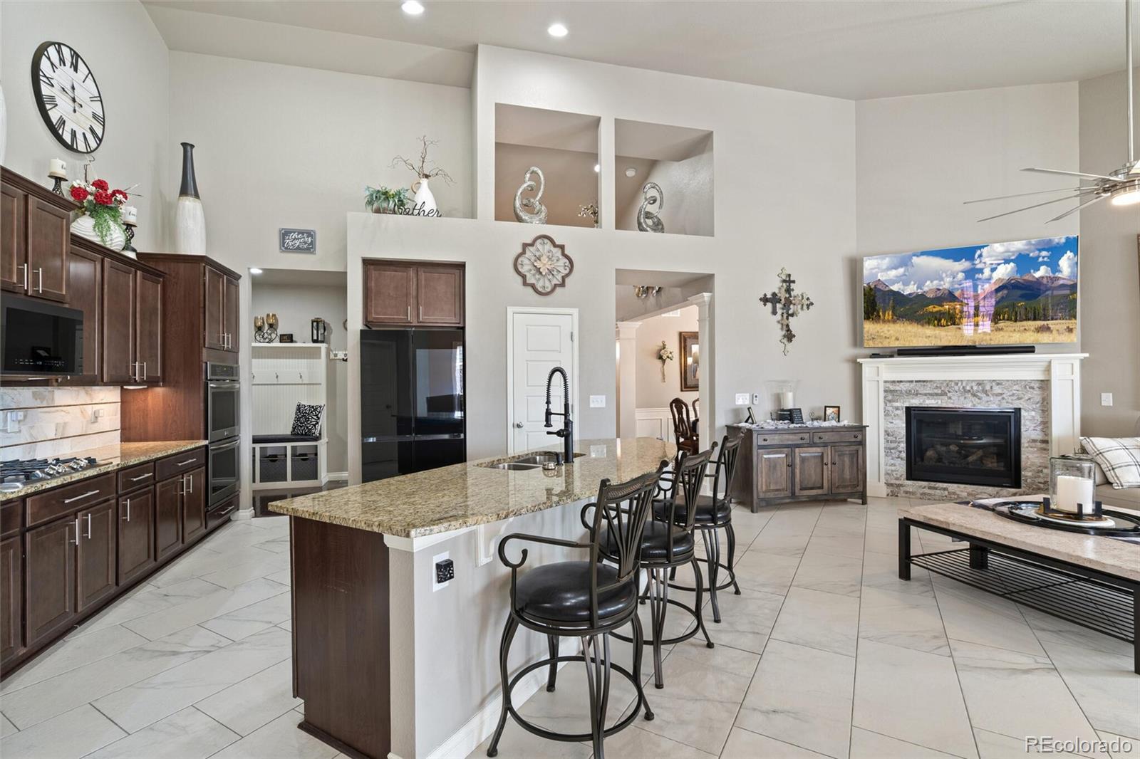 8841 Peakview Avenue Firestone, CO 80504 - Photo 5 of 40 a living room with stainless steel appliances furniture a fireplace kitchen view and a flat screen tv