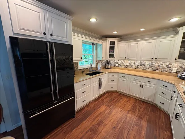 a kitchen with stainless steel appliances a refrigerator sink and cabinets