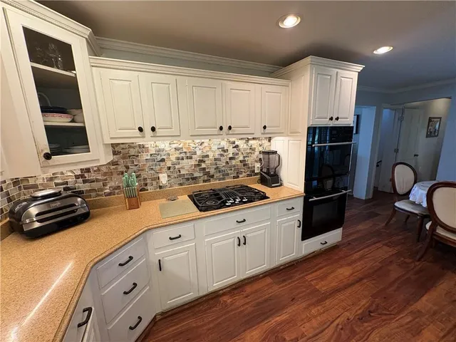 a kitchen with granite countertop a stove a sink and a refrigerator