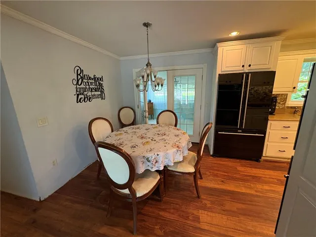 a dining room with furniture a chandelier and wooden floor