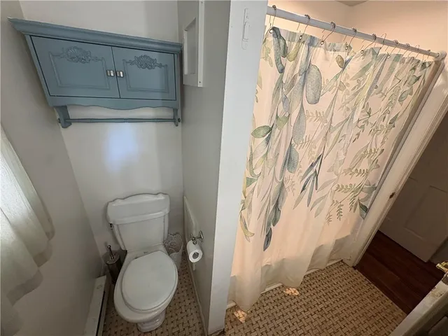 a bathroom with a toilet and a shower curtain