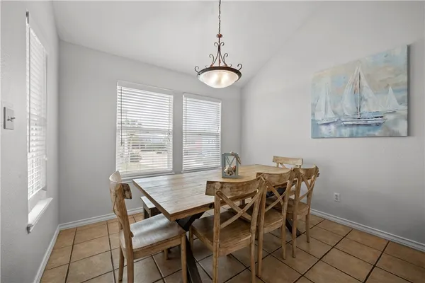 a kitchen with stainless steel appliances kitchen island a table chairs in it and wooden floors
