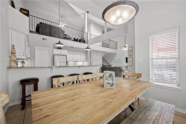 a kitchen with stainless steel appliances granite countertop a refrigerator a stove and white cabinets with wooden floor