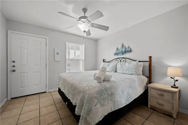 a spacious bedroom with a bed and a flat screen tv