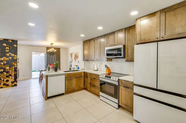 a kitchen with stainless steel appliances granite countertop a refrigerator sink and stove