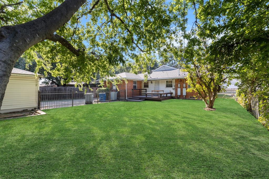 6317 Ravendale Lane Dallas, TX 75214 - Photo 14 of 16 a front view of a house with a garden and trees