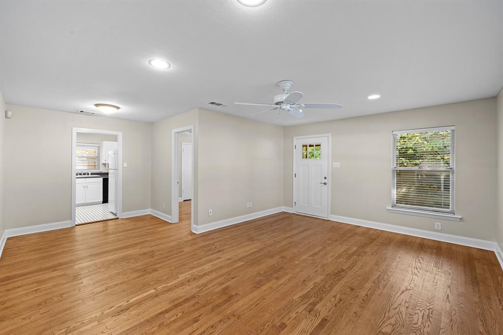 6317 Ravendale Lane Dallas, TX 75214 - Photo 5 of 16 a view of an empty room with wooden floor and a window