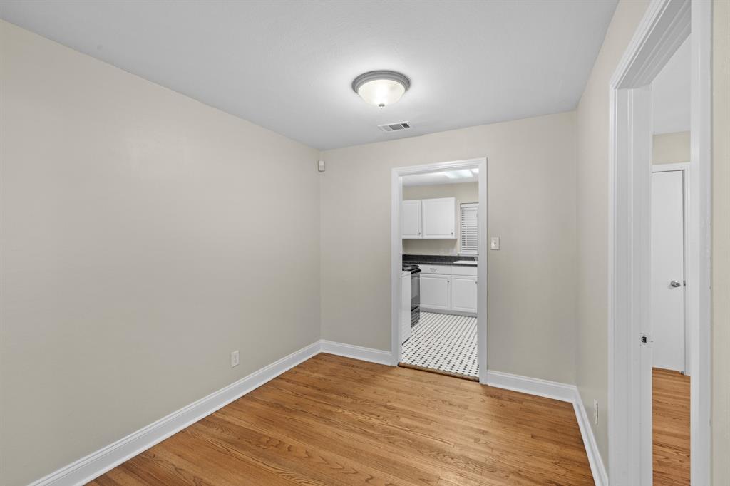 6317 Ravendale Lane Dallas, TX 75214 - Photo 6 of 16 a view of empty room with wooden floor and kitchen