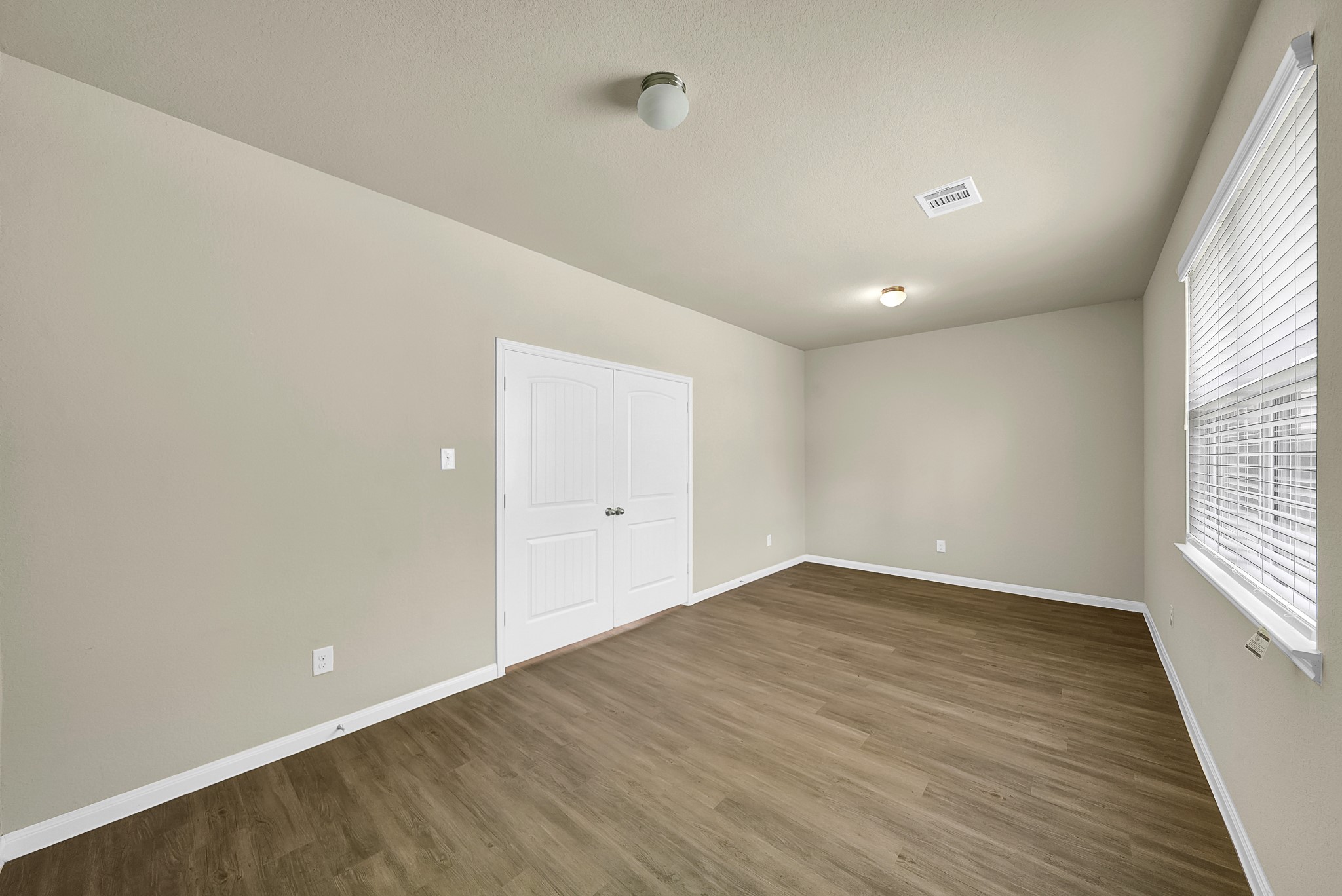 4274 McGregor Blf Lane Conroe, TX 77304 - Photo 21 of 25 wooden floor in an empty room with a window