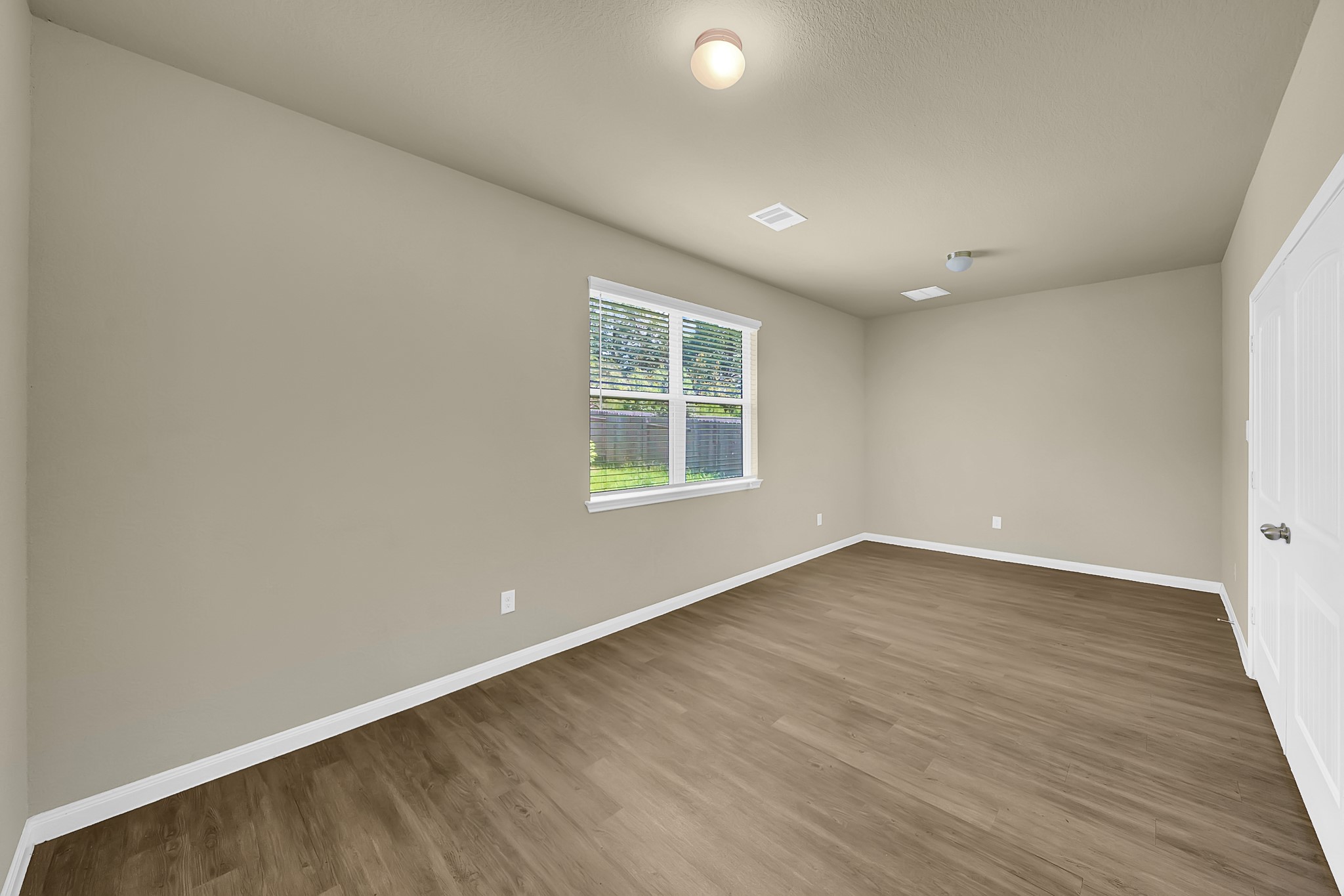 4274 McGregor Blf Lane Conroe, TX 77304 - Photo 22 of 25 an empty room with wooden floor and windows