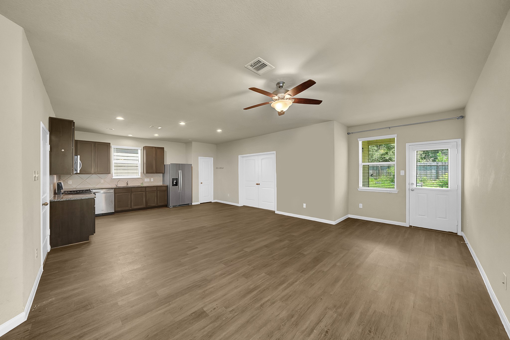 4274 McGregor Blf Lane Conroe, TX 77304 - Photo 4 of 25 a view of an empty room with a kitchen and wooden floor