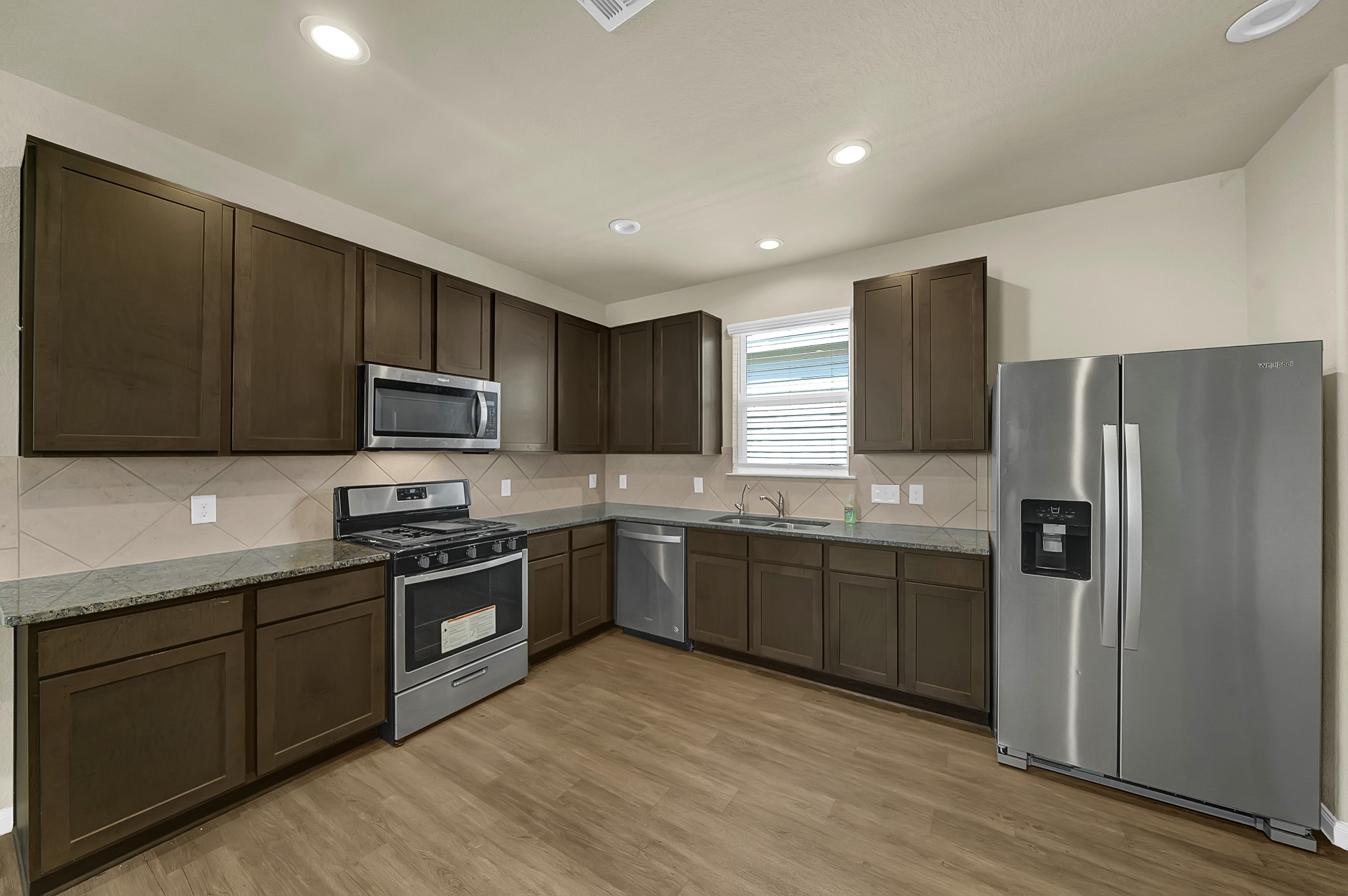 4274 McGregor Blf Lane Conroe, TX 77304 - Photo 6 of 25 a kitchen with stainless steel appliances granite countertop a refrigerator stove microwave and sink