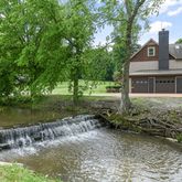 a front view of a house with a yard and lake view