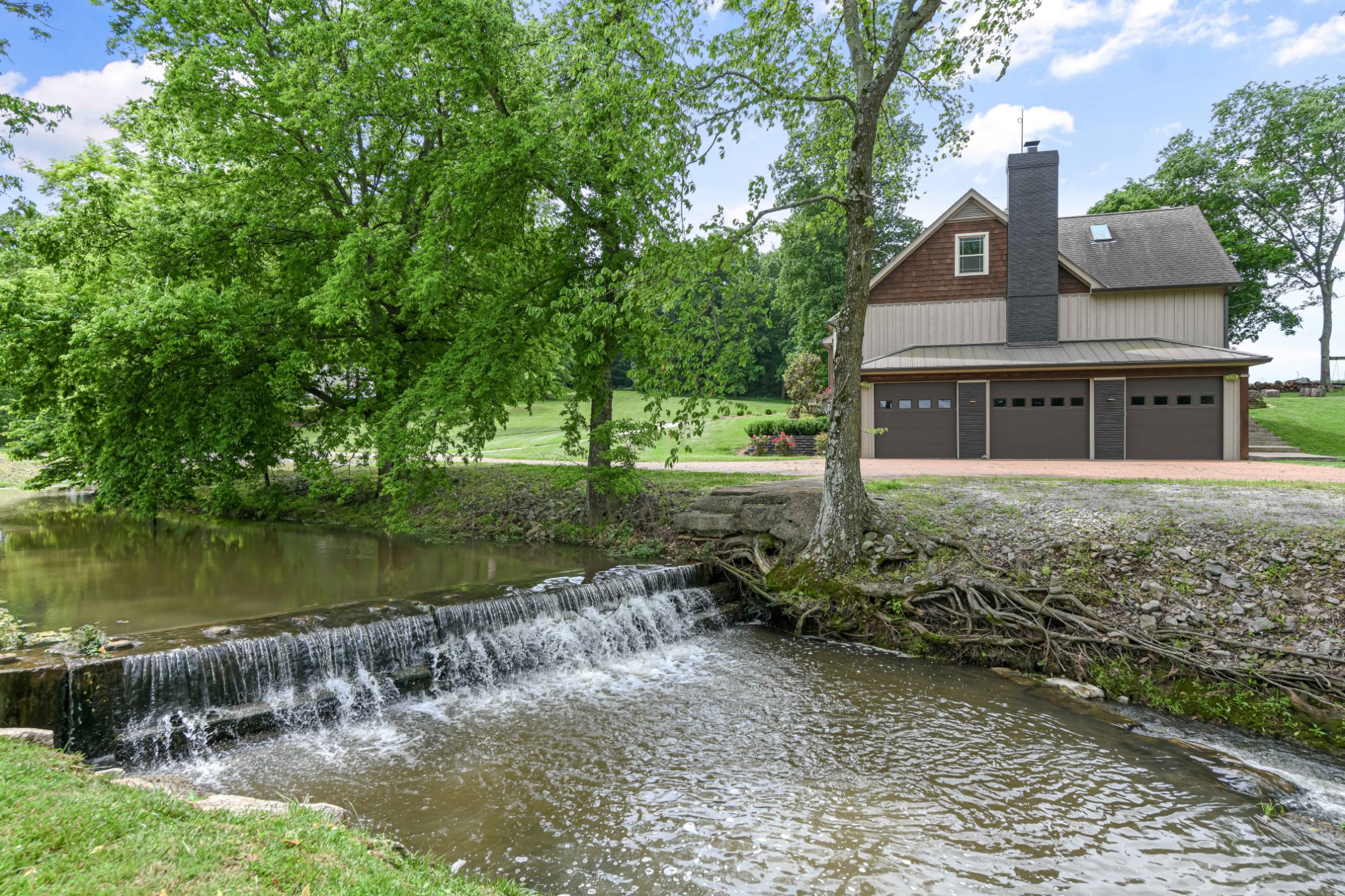 a front view of a house with a yard and lake view