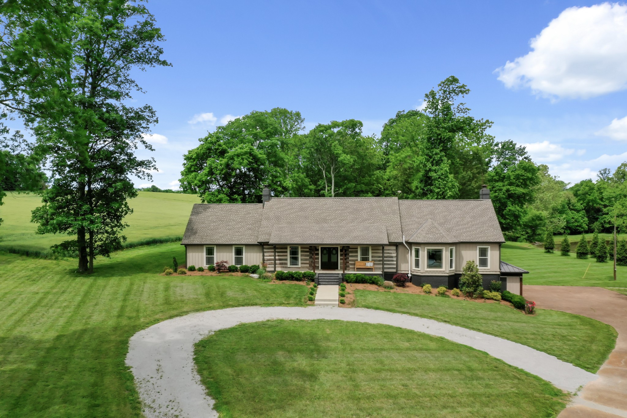 6557 Lamont Road Springfield, TN 37172 - Photo 36 of 62 a view of a white house with a yard plants and large tree