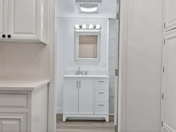 a bathroom with a sink a mirror and cabinets