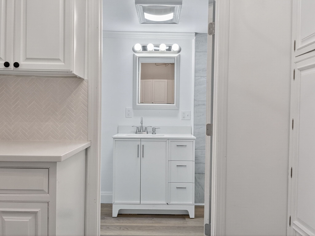 44 Liberty Street Randolph, MA 02368 - Photo 12 of 41 a bathroom with a sink a mirror and cabinets