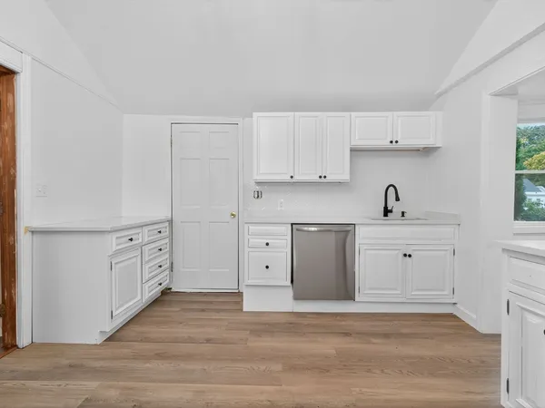 a kitchen with white cabinets and white appliances