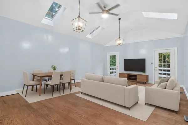 a living room with furniture a dining table and a flat screen tv