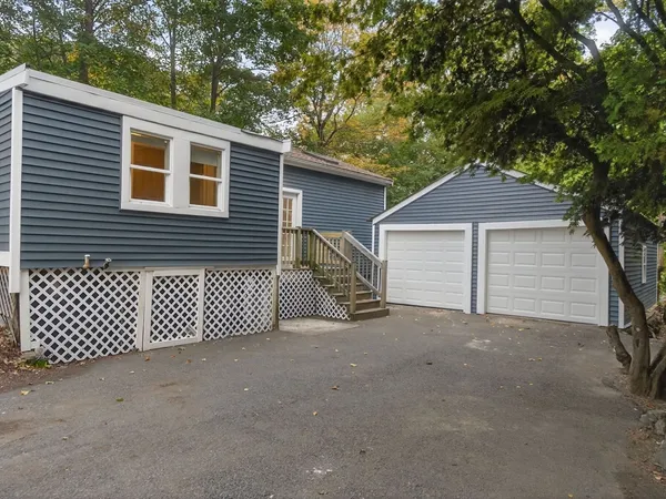 a view of backyard of house with wooden fence and trees