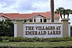 a front view of a house with a garden and signage