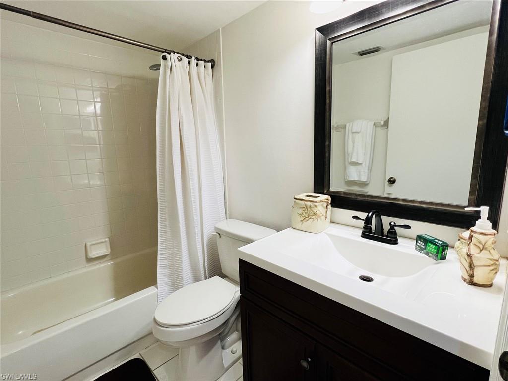 7719 Jewel Lane, Unit 103 Naples, FL 34109 - Photo 14 of 16 a bathroom with a sink a toilet and shower