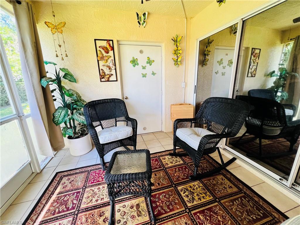 7719 Jewel Lane, Unit 103 Naples, FL 34109 - Photo 15 of 16 a living room with a rug and a window