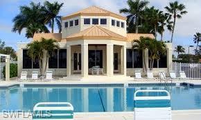 7719 Jewel Lane, Unit 103 Naples, FL 34109 - Photo 2 of 16 a front view of a house with swimming pool and glass windows