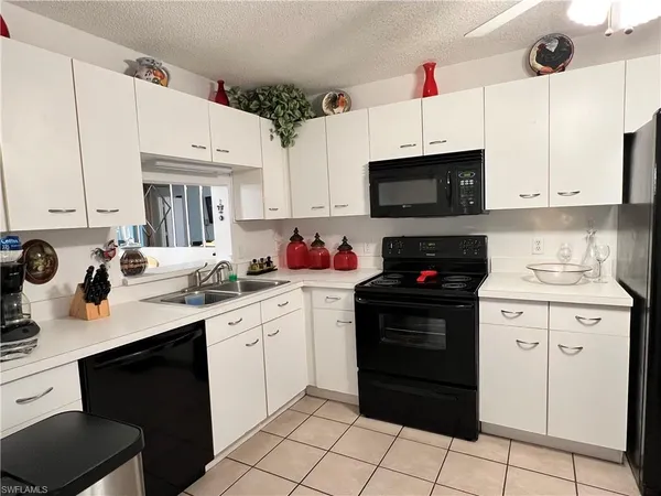 a kitchen with cabinets a sink and white appliances