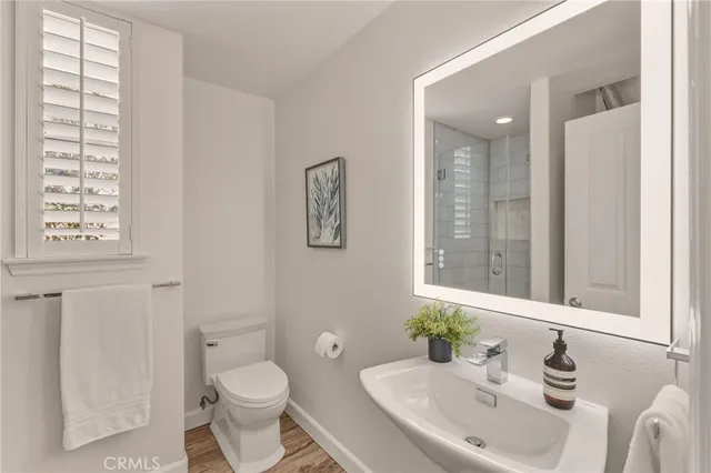 a bathroom with a toilet a sink and mirror