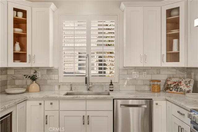 a kitchen with stainless steel appliances granite countertop a sink a window and cabinets