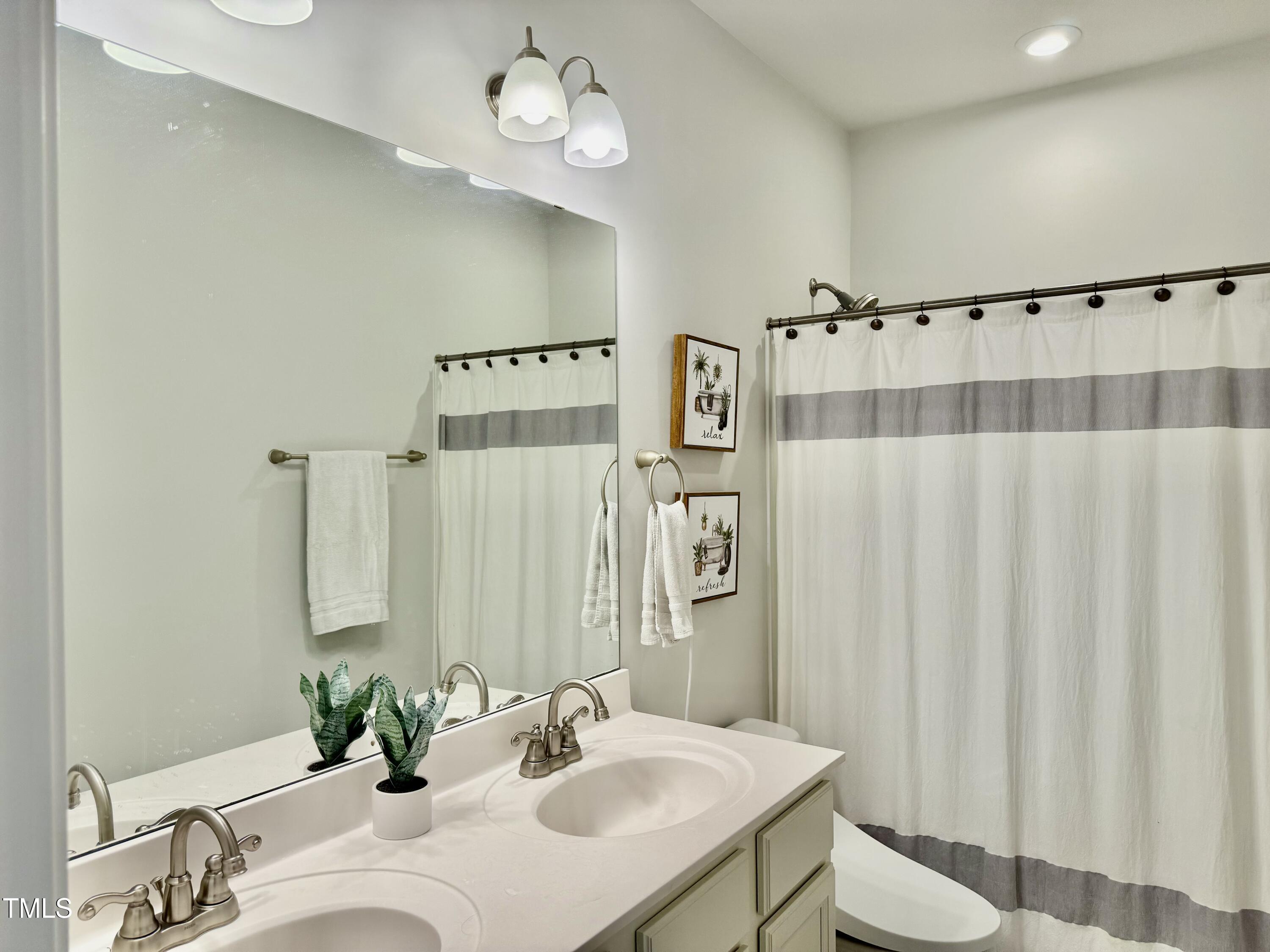 8600 Deep Elm Drive Wake Forest, NC 27587 - Photo 13 of 21 a bathroom with a sink a toilet and a mirror