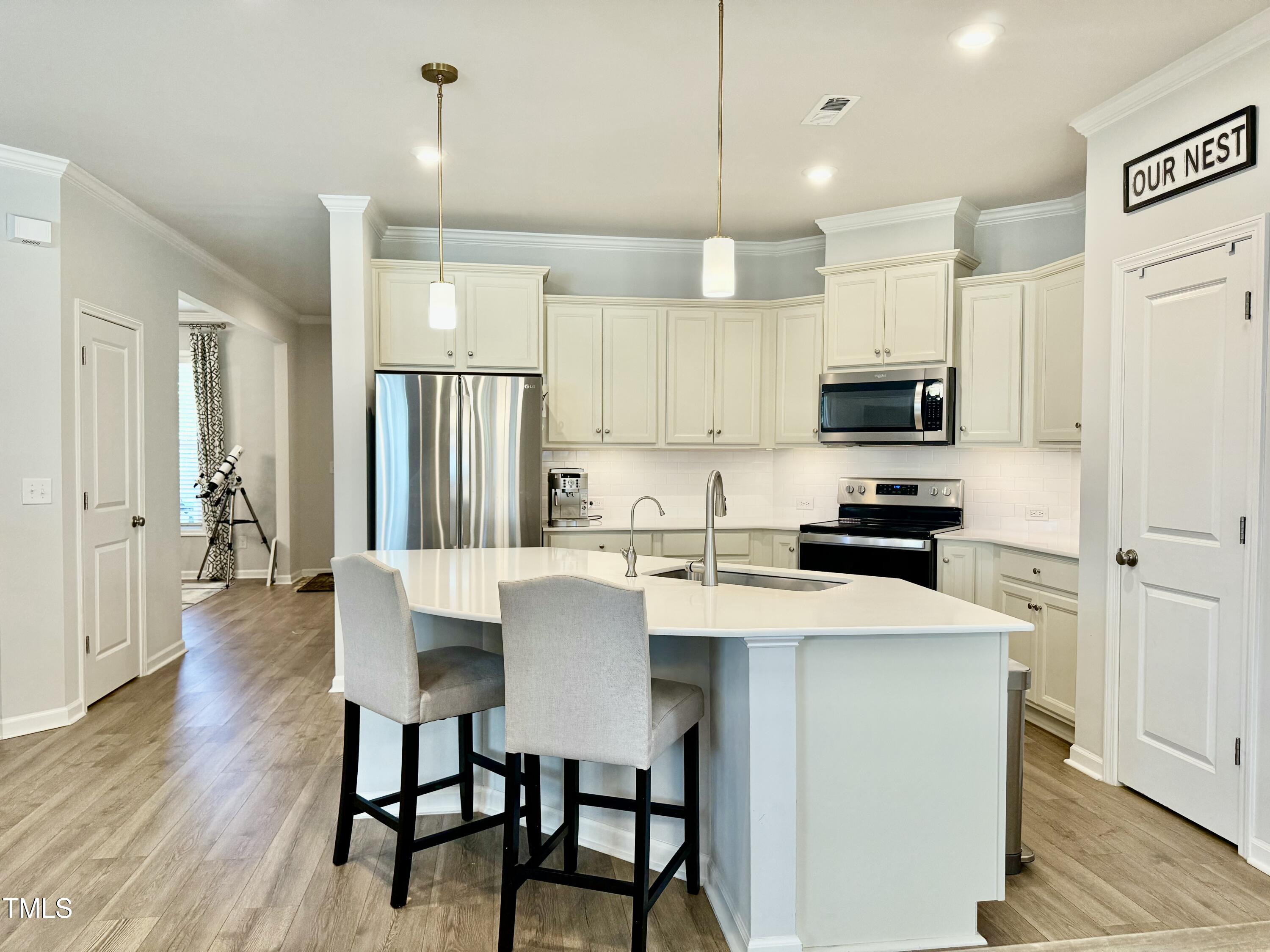 8600 Deep Elm Drive Wake Forest, NC 27587 - Photo 6 of 21 a kitchen with kitchen island a dining table chairs and a refrigerator