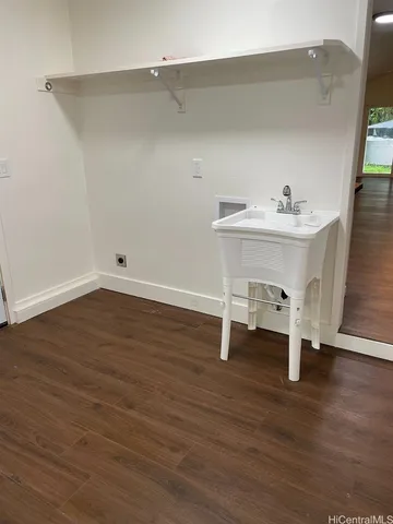 an empty room with wooden floor and white walls